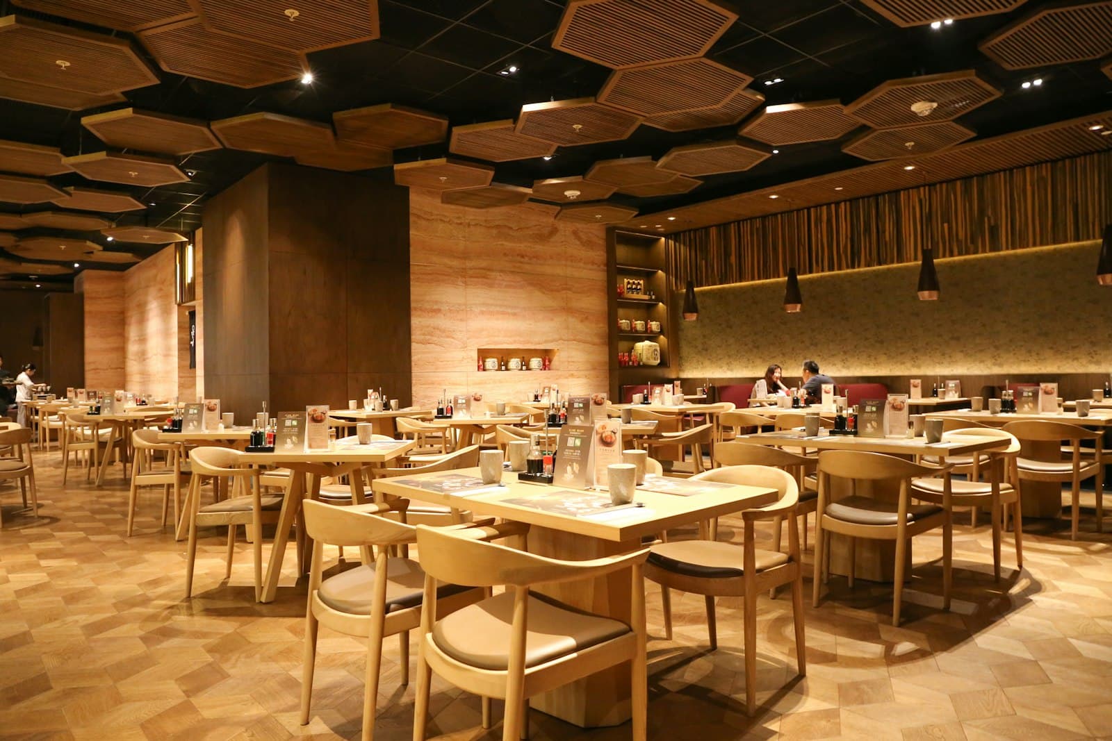 飲食店のイメージ——木の六角天井と木製テーブル席の店内